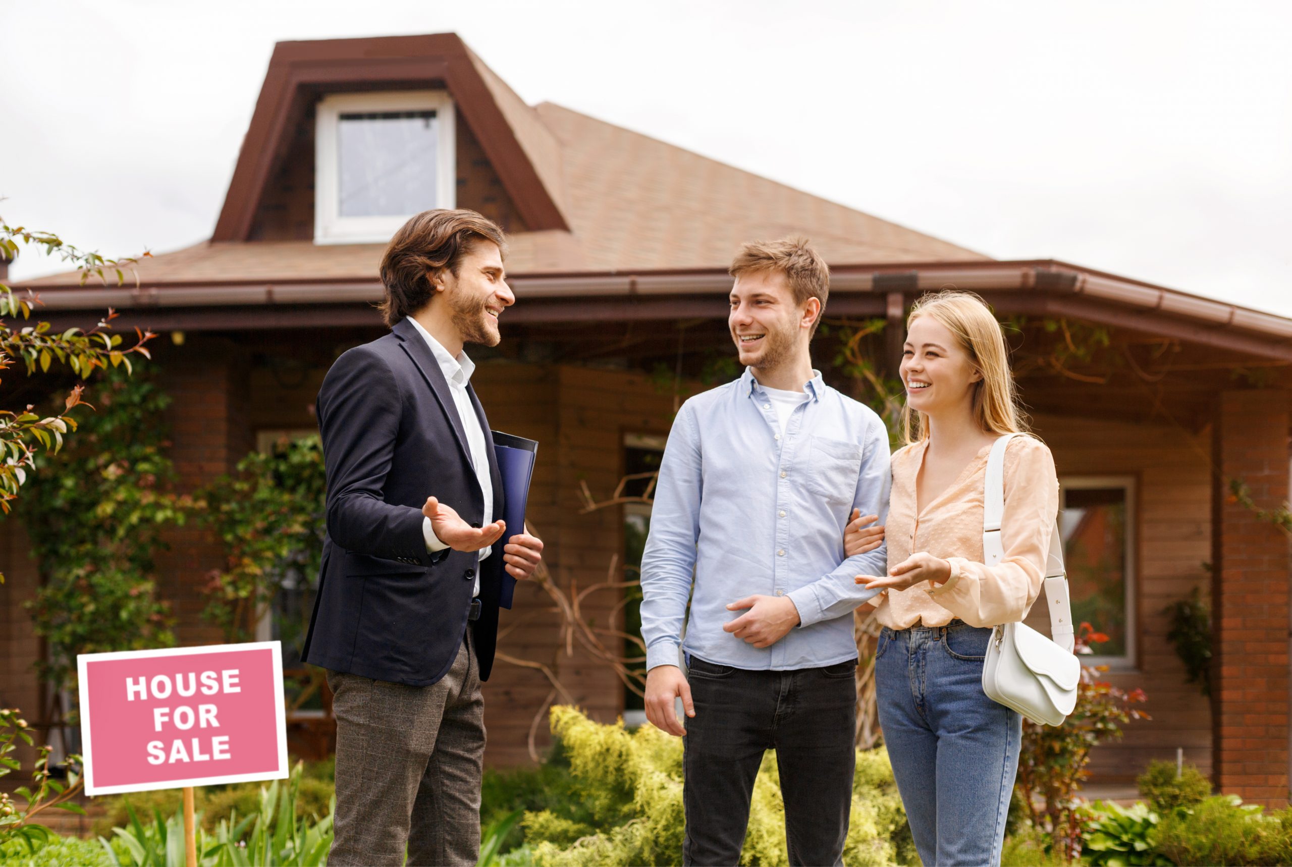 Young family talking to real estate agent about purchasing property near beautiful house outside
